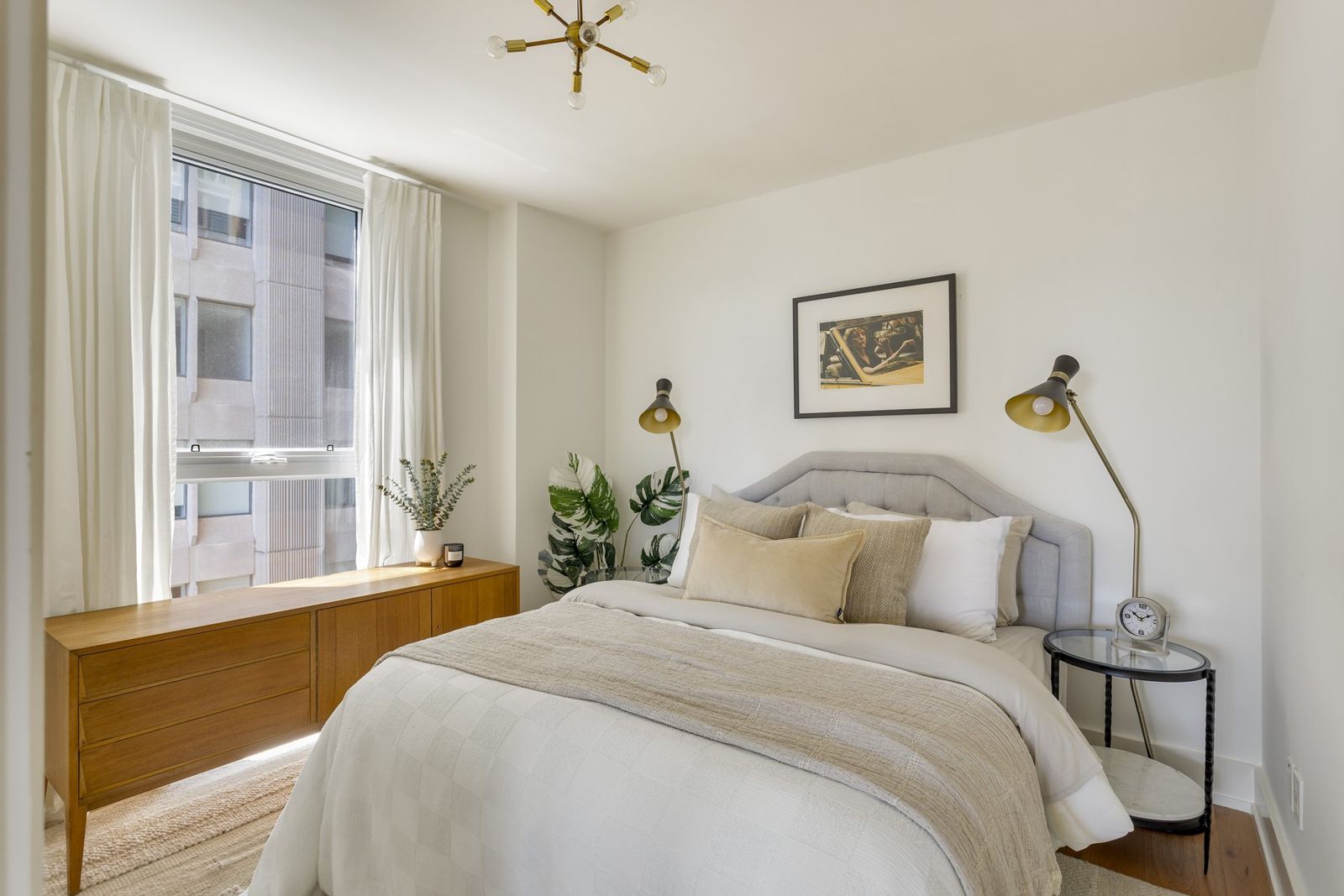 Bedroom with brass reading lights and layered bedding