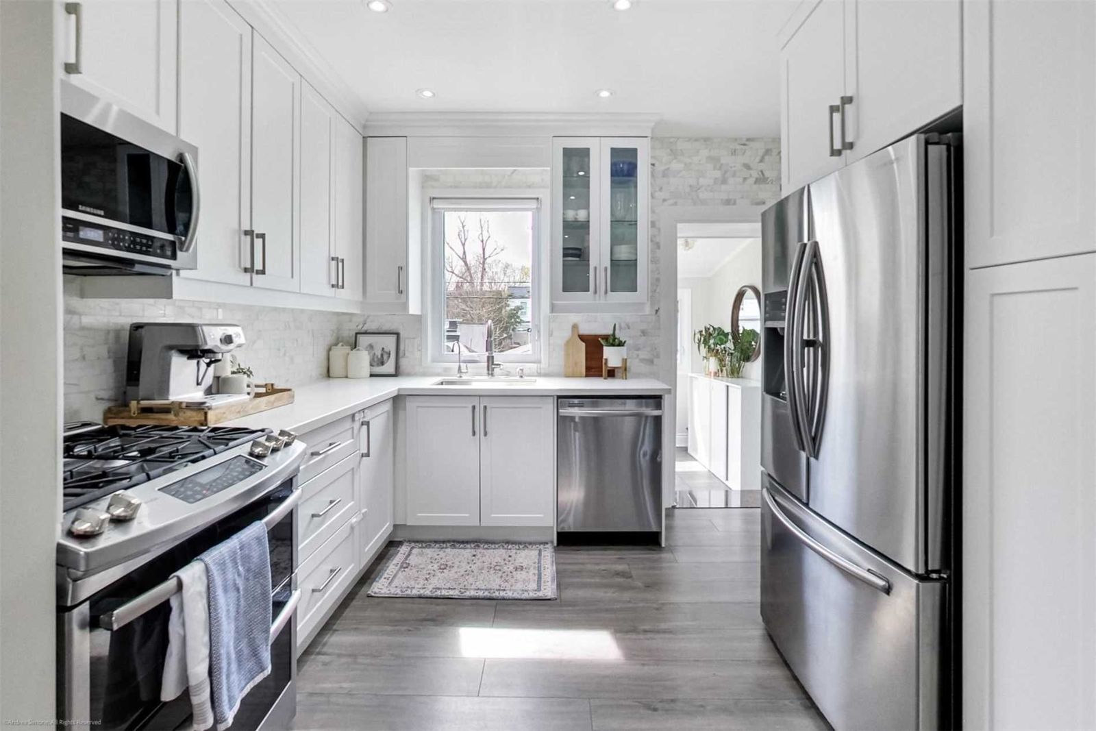 After: an opened layout with cabinetry run toward the ceiling and a pantry beside the refrigerator