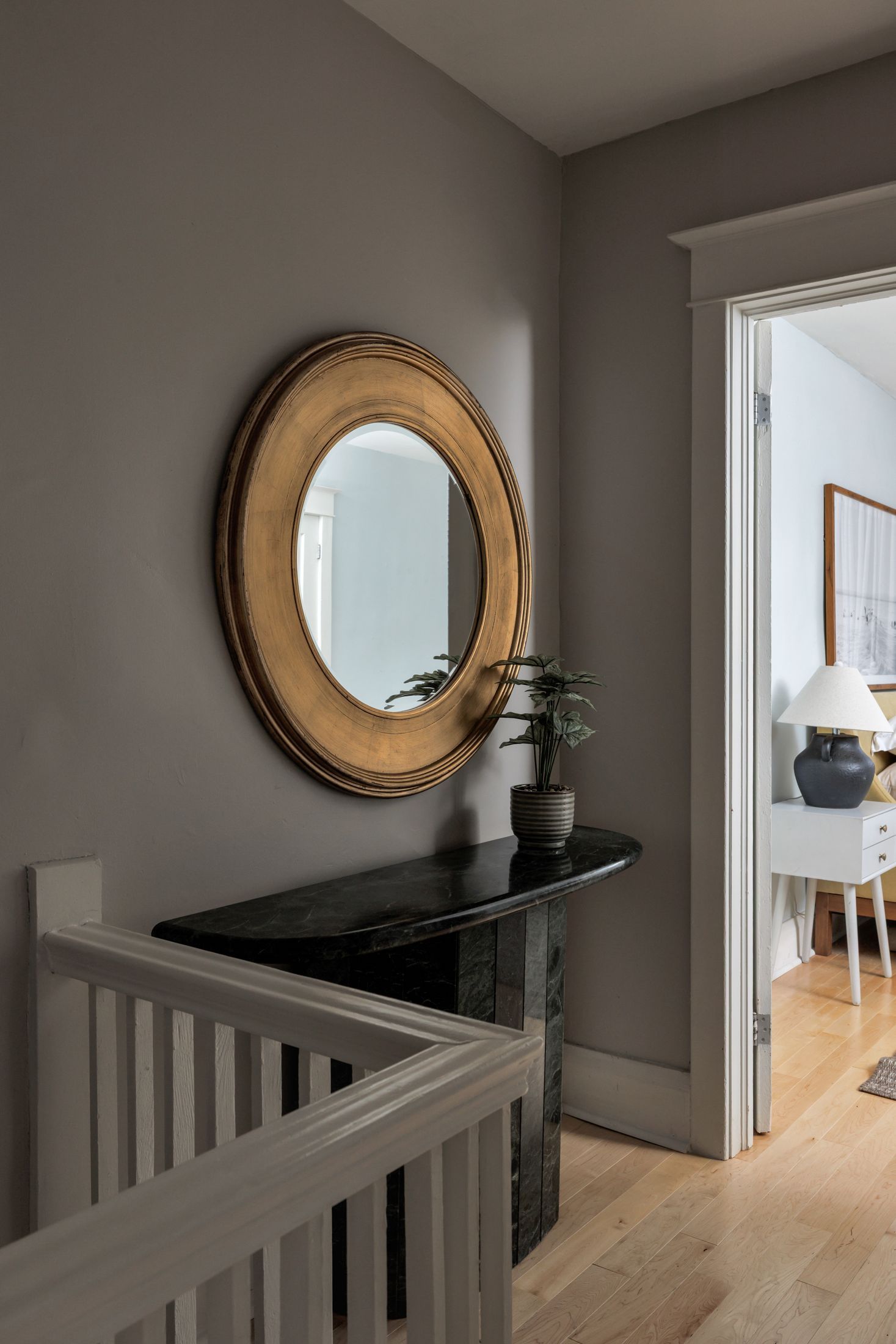 Upstairs hallway with a round mirror